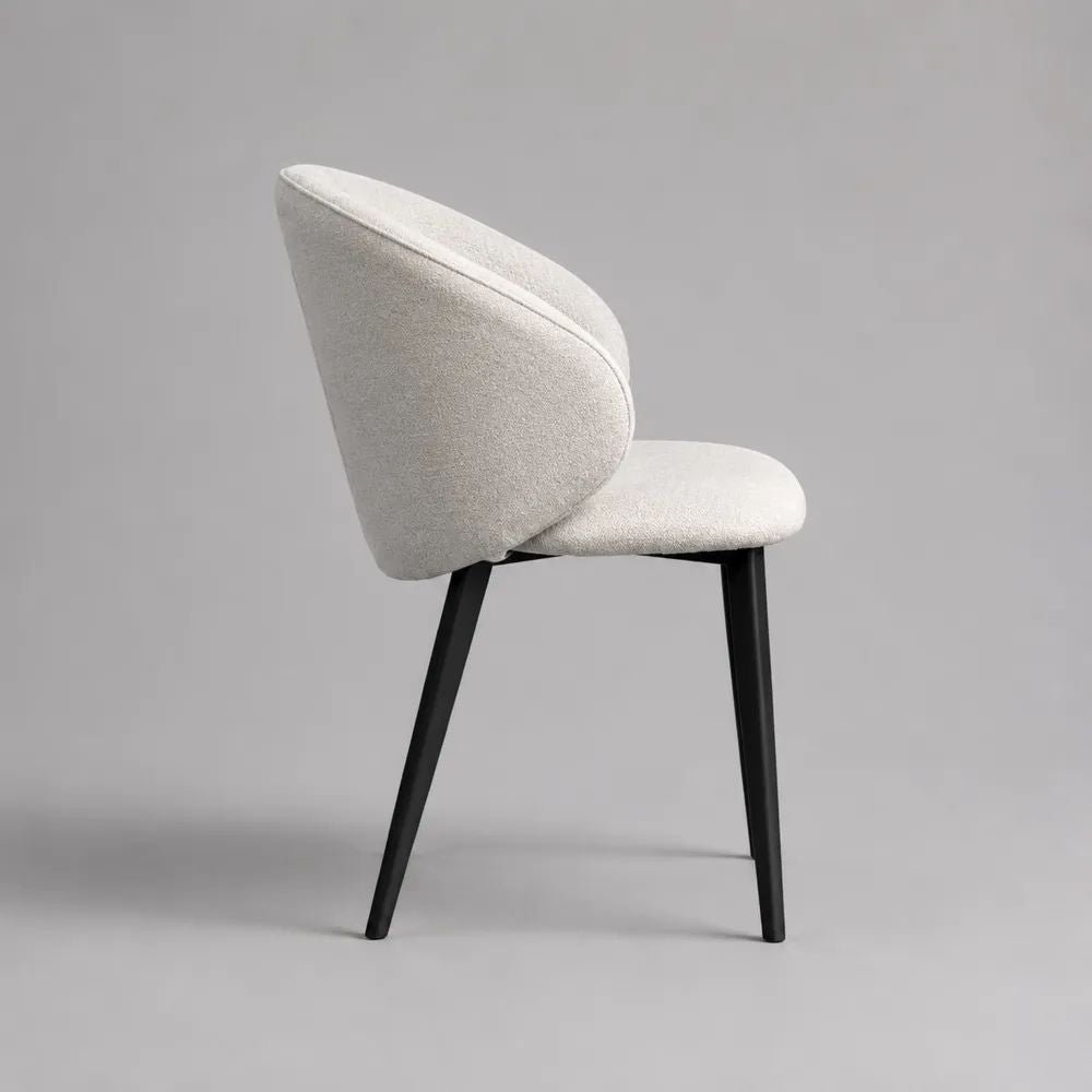 Sedia da pranzo imbottita in bouclé bianco crema con schienale curvo e gambe in acciaio nero, 57 × 60 × 80 cm